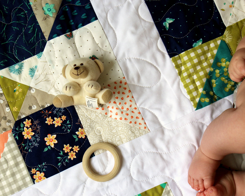 Classic Nine Patch Baby Quilt with a twist, bear toy, teething toy, and adorable baby legs